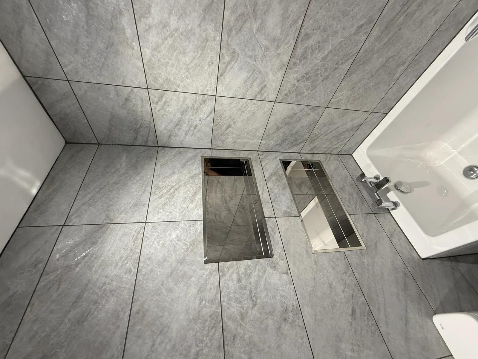 Professional bathroom plumbing installation with tiled floors and fixtures